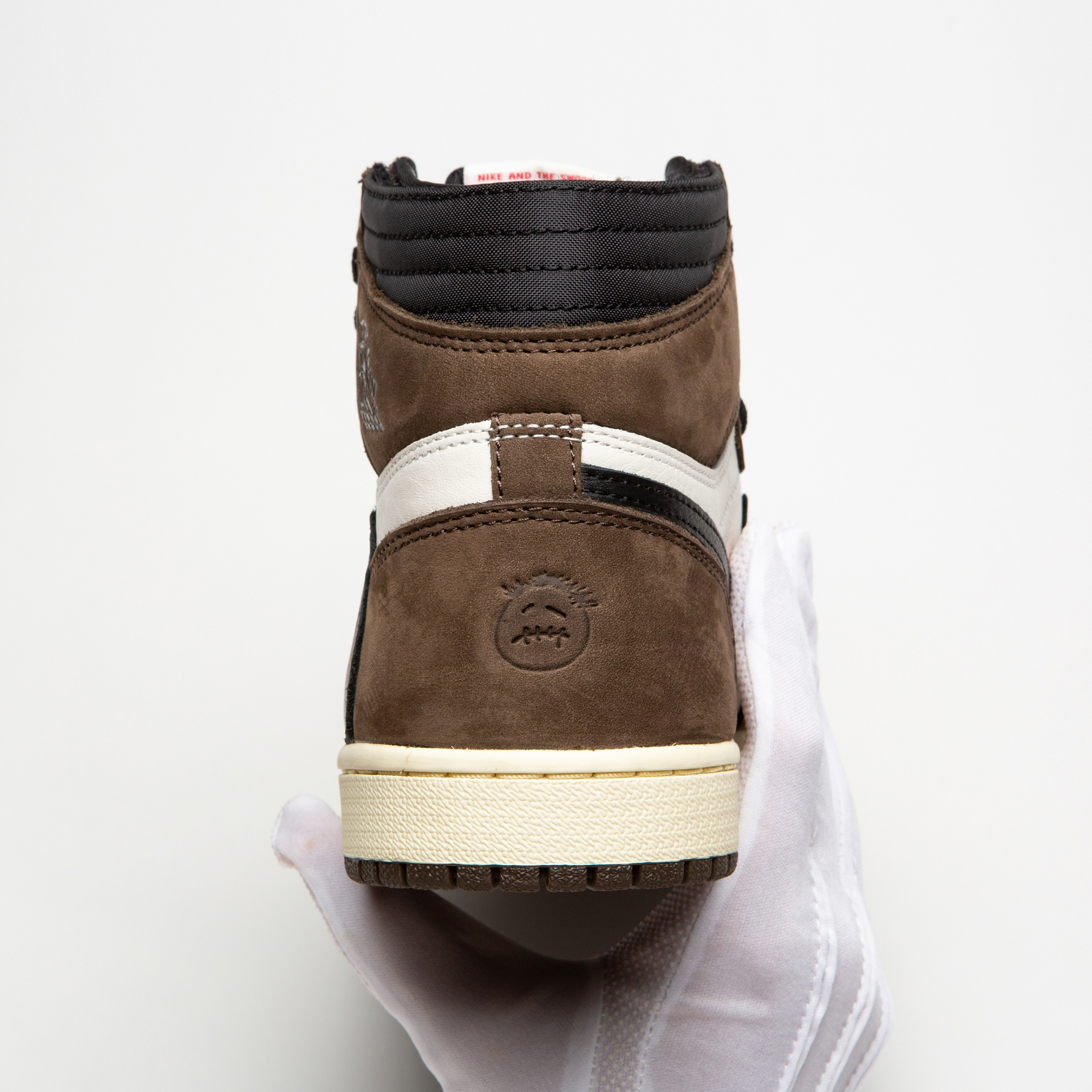 Hånd der holder en brun sneaker, verificering af produktet