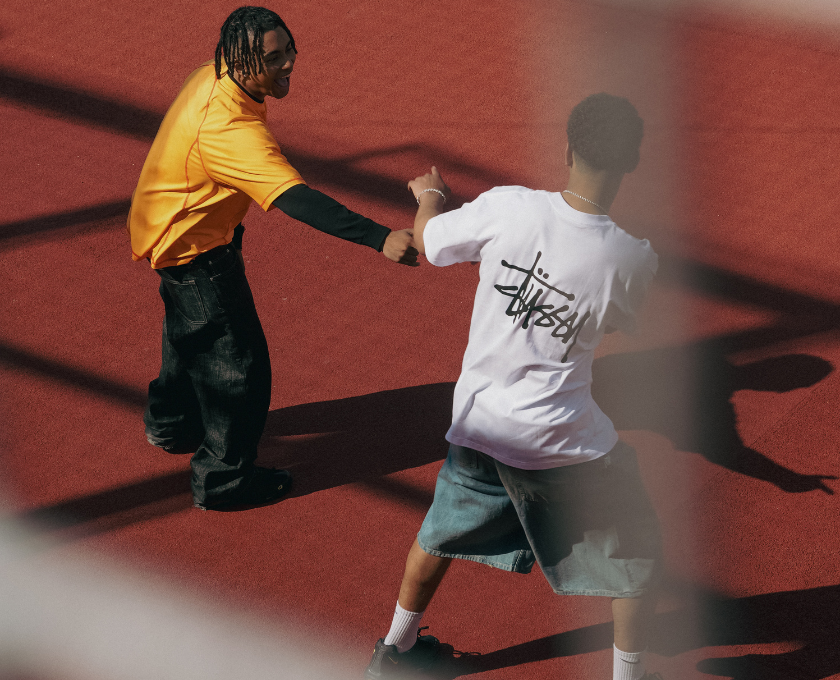 To unge mænd i streetwear-tøj på en rød bane, kigger på hinanden